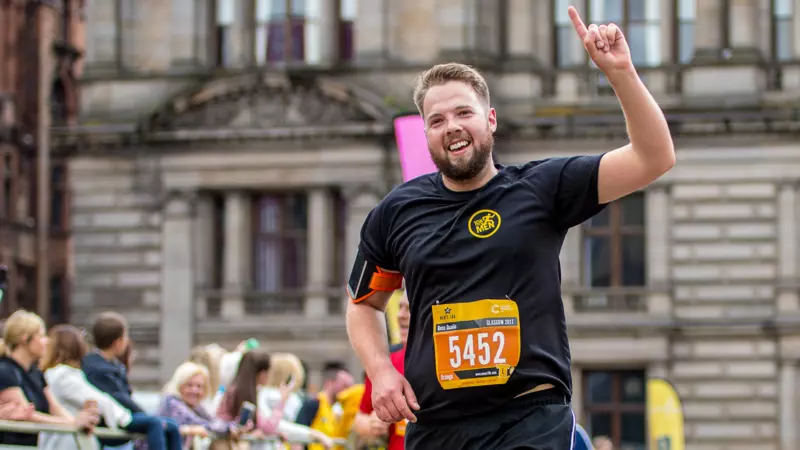 A man running in the Glasgow Men's 10k wearing a black running top. 