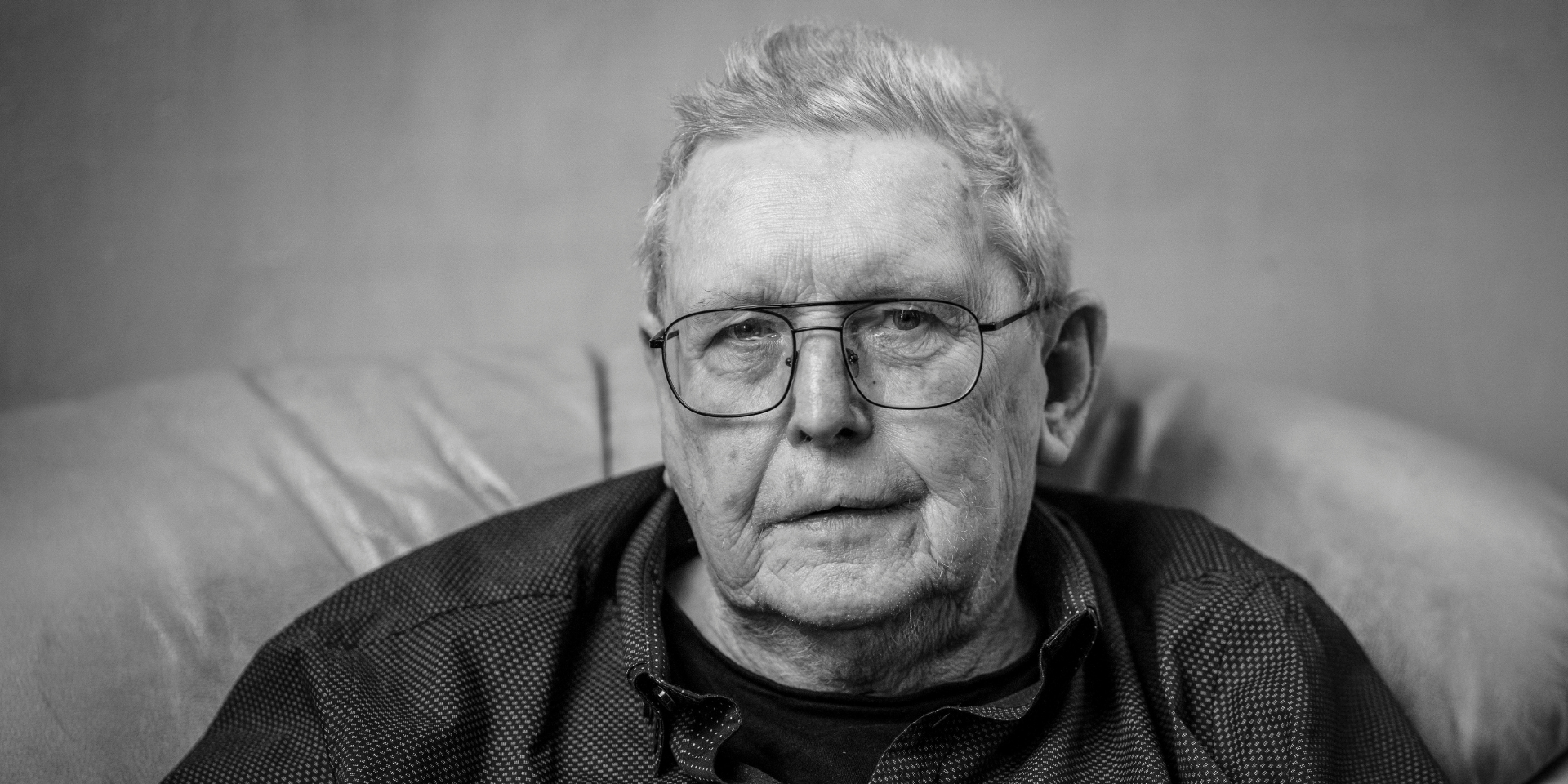 A black and white picture of Alex, an older man wearing glasses